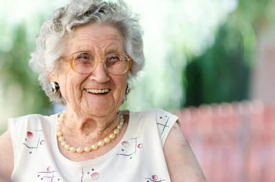 Smiling elderly woman sitting outside