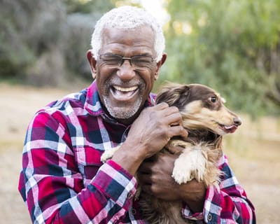 Smiling resident enjoying the outdoors with a dog