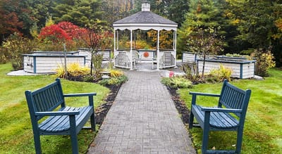 Garden gazebo surrounded by seating and landscaped flowers
