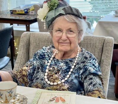 Resident wearing a decorative hat in a cozy common area