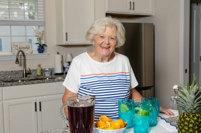 Senior resident enjoying refreshments in a kitchen