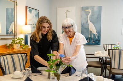 Staff assisting a resident in a dining area