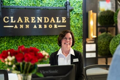 Reception area with staff member and greenery