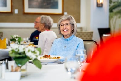 Resident enjoying a meal in the dining area