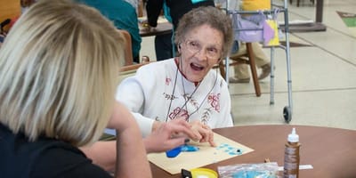Resident engaged in a hands-on activity with staff