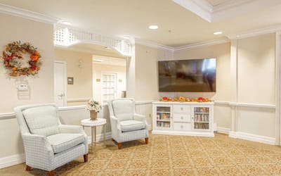 Common area with seating and TV in a senior living facility