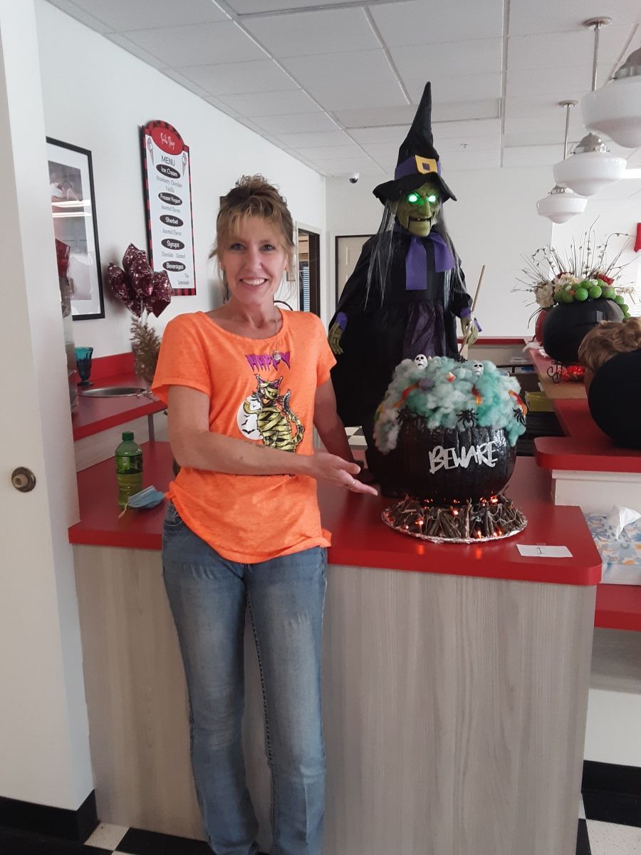 A staff member with Halloween decorations in a common area