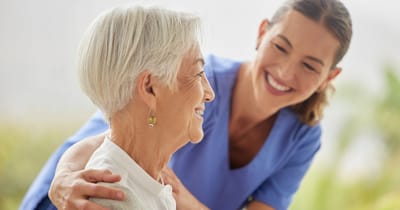 A caregiver smiling with a senior resident