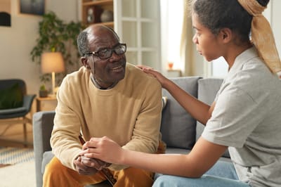 A resident talking with a caregiver in a cozy living room