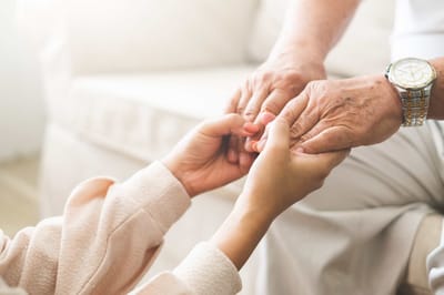A caregiver holding hands with a senior resident