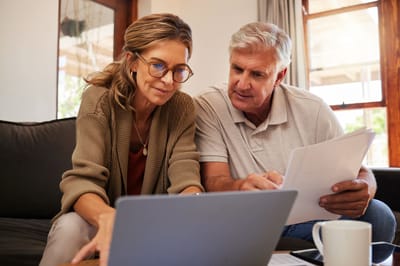 Older couple using a laptop together in a cozy setting