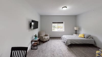 Cozy resident room with a bed and chair