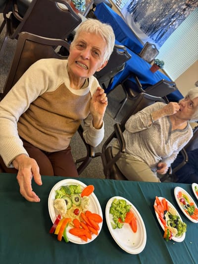Residents enjoying a meal with fresh vegetables
