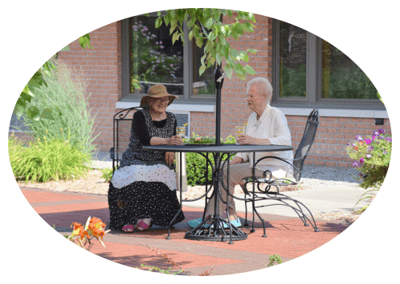 Two residents enjoying conversation at an outdoor table