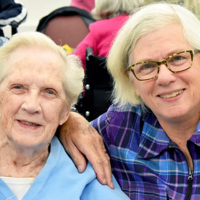 Resident and staff member smiling together