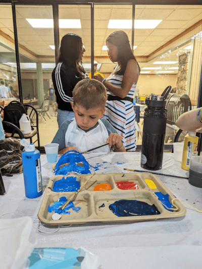 Children painting during an activity in a common area