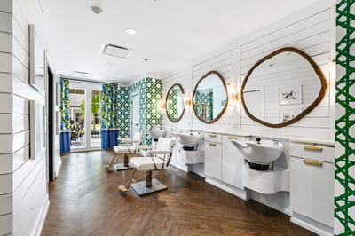 Bright salon area with comfortable chairs and mirrors