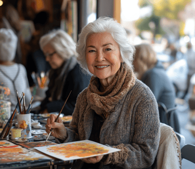 Elderly woman painting with watercolors in a cozy setting