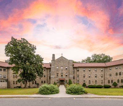 Exterior view of Monastery Heights facility among trees