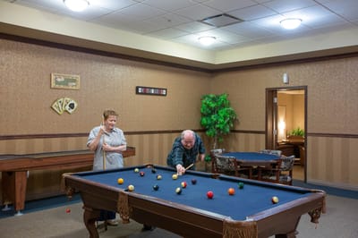 Residents enjoying a game of billiards in a lounge area