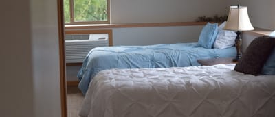 A shared resident room with two beds and a lamp