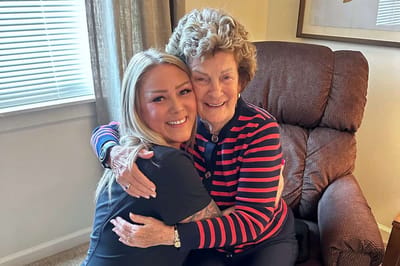 Caregiver and resident sharing a warm embrace