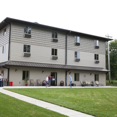 Residents and staff outside a modern assisted living building