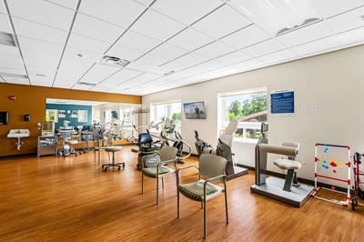 Physical therapy room with exercise equipment and seating