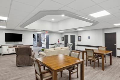 Common area with tables and seating in a senior living facility