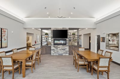Bright common area with dining tables and fireplace