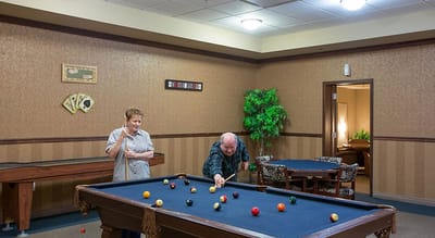 Residents playing billiards in a common area