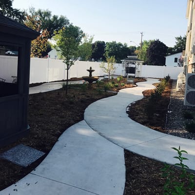 The Harbors Senior Living of Fridley, assisted living in St. Louis, MO — Winding pathway through landscaped garden with fountain