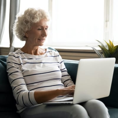 Senior woman using a laptop in a cozy interior setting