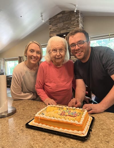 Resident celebrating birthday with staff and cake