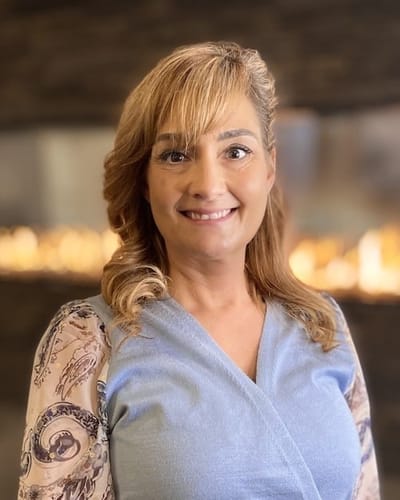 Staff member smiling in a welcoming indoor setting