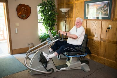 Resident using exercise equipment in a fitness area