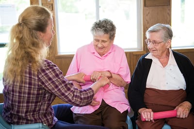 Staff assisting residents in an activity room