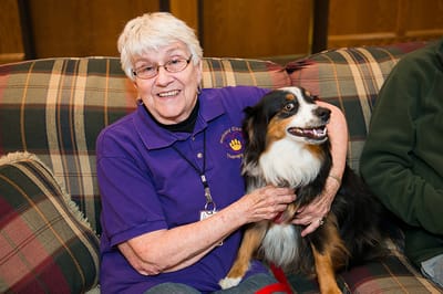 A resident enjoying time with a therapy dog