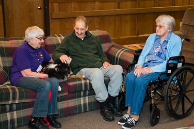 Residents engaging with staff in a cozy common area