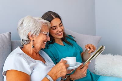 A caregiver and resident sharing a moment over coffee