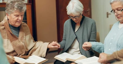 Residents engaged in a prayer circle with books