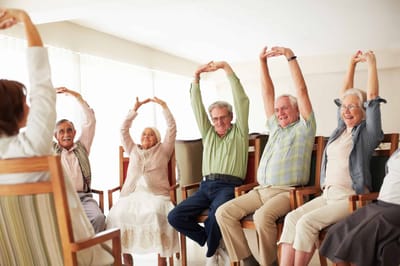 Residents participating in a seated exercise class