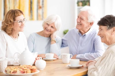 Residents enjoying tea and pastries in a common area