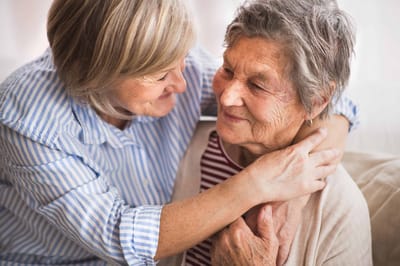 Caregiver embracing a senior resident with a warm expression