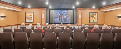 Residents enjoying a movie in a theater room