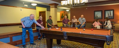 Residents enjoying a game of pool in the common area