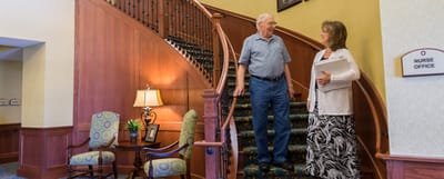 Resident and staff member talking at the stairs