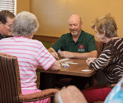 Residents and staff enjoying a card game together
