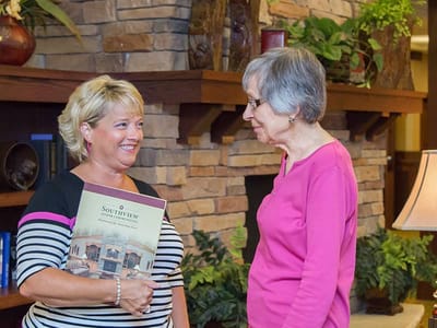 Staff interacting with a resident in a cozy common area