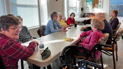 Residents engaged in a game around a table